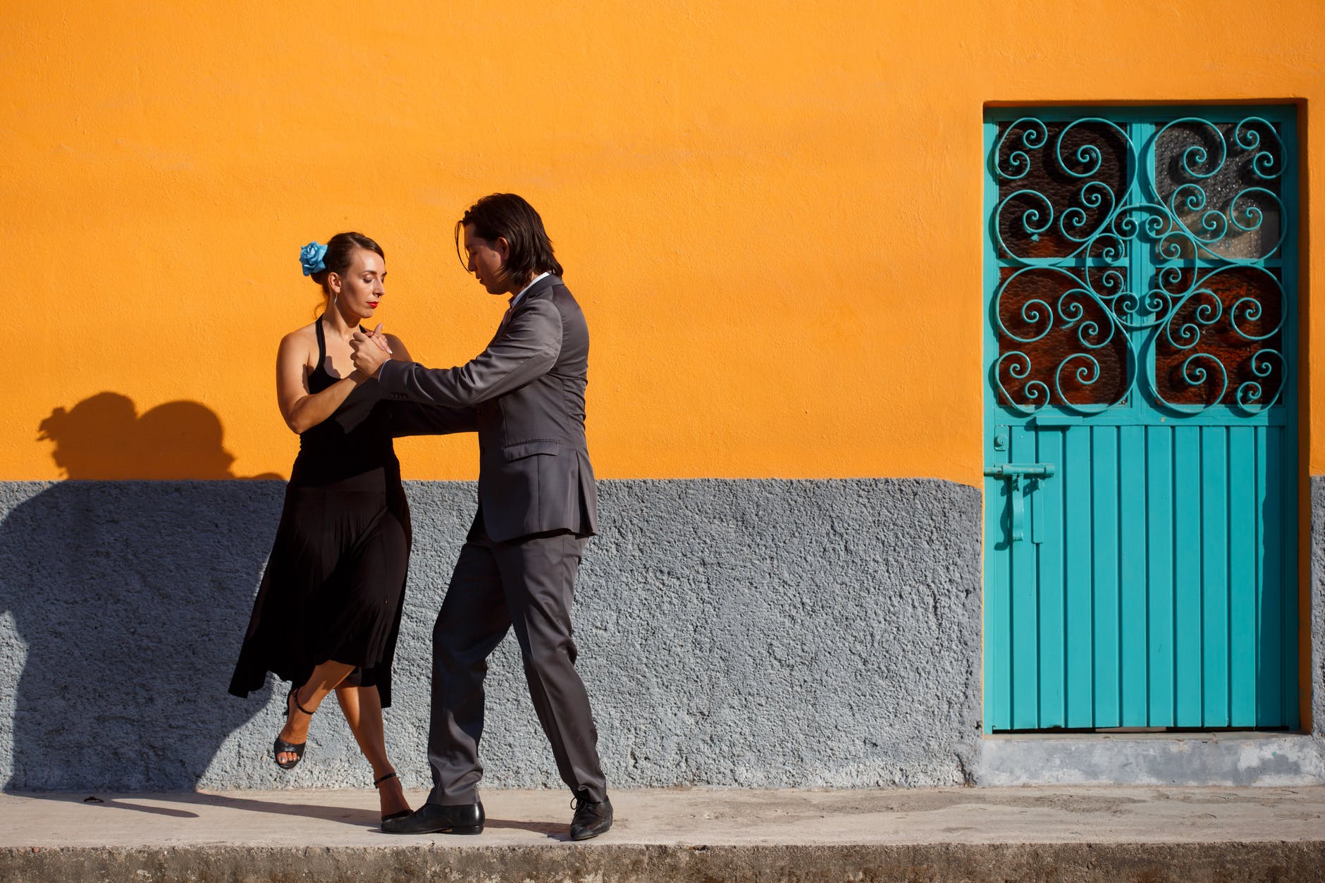 man and woman kissing near blue and orange wall
